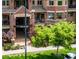 Exterior entrance of a condo building featuring lush landscaping, brickwork, and an awning at 1100 N Grant St # 208, Denver, CO 80203