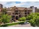 Beautiful exterior shot of a multi-story condo building with manicured landscaping and mature trees in a residential area at 1100 N Grant St # 208, Denver, CO 80203