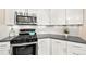 Bright kitchen features white cabinetry, stainless steel appliances, and granite countertops at 1100 N Grant St # 208, Denver, CO 80203