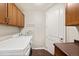 Functional laundry room with wooden cabinets, a white washer and dryer at 1100 N Grant St # 208, Denver, CO 80203