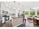 Open-concept kitchen and living area with stainless steel appliances, a breakfast bar, and natural light at 1100 N Grant St # 208, Denver, CO 80203