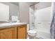 Bathroom with tiled shower-tub, wood vanity, and framed mirror at 5552 Flanders Way, Denver, CO 80249