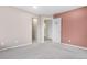 Bedroom with an open doorframe between neutral and rose-colored walls and carpeted floors at 5552 Flanders Way, Denver, CO 80249