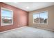 Sunlit bedroom with carpet, dual windows offering neighborhood views, and walls painted in neutral tones at 5552 Flanders Way, Denver, CO 80249