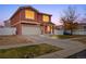 Charming home featuring stucco exterior, tiled roof, two-car garage, and a welcoming covered front porch at 5552 Flanders Way, Denver, CO 80249