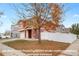 Charming two-story home featuring a two-car garage, white fence, and a lovely front yard with mature tree at 5552 Flanders Way, Denver, CO 80249
