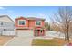 Charming home featuring stucco exterior, tiled roof, two-car garage, and a welcoming covered front porch at 5552 Flanders Way, Denver, CO 80249