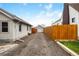 Backyard view of the driveway and detached garage, including a wooden fence at 134 N 6Th Ave, Brighton, CO 80601