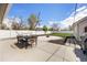 Inviting backyard with patio, dining set, fire pit, green grass, and white privacy fence at 134 N 6Th Ave, Brighton, CO 80601