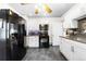 Updated kitchen featuring black appliances, white cabinets, and granite countertops at 134 N 6Th Ave, Brighton, CO 80601