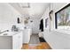 Bright laundry room featuring a utility sink, washer, dryer, windows, and storage at 134 N 6Th Ave, Brighton, CO 80601