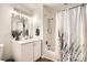 Bright bathroom with white cabinets, updated fixtures and shower-tub combo at 3100 Huron St # 3E, Denver, CO 80202