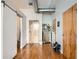 Hallway with wood flooring, a sliding barn door, and multiple entry doors offer a flexible space at 3100 Huron St # 3E, Denver, CO 80202