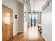 Bright hallway with hardwood floors, white walls, modern accents, and large windows for natural light at 3100 Huron St # 3E, Denver, CO 80202