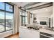 Well-lit kitchen featuring stainless steel appliances, a breakfast bar, and bright natural light from a large window at 3100 Huron St # 3E, Denver, CO 80202