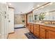 Elegant bathroom featuring dual sinks, a soaking tub with decorative tile, and ample vanity storage at 29477 Blue Moon Dr, Evergreen, CO 80439