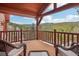 Relaxing covered wood deck featuring log beams and scenic mountain views at 29477 Blue Moon Dr, Evergreen, CO 80439