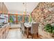 Elegant dining room with stone accent wall and forest view from large windows at 29477 Blue Moon Dr, Evergreen, CO 80439