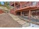 Stone steps leading to the house with a stone foundation and a multi-level deck at 29477 Blue Moon Dr, Evergreen, CO 80439