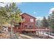 Beautiful home with a large deck, stone foundation, and surrounded by trees at 29477 Blue Moon Dr, Evergreen, CO 80439