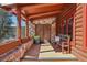 Charming stone and wood porch with custom doors and cozy seating at 29477 Blue Moon Dr, Evergreen, CO 80439