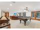 Entertaining game room with pool table, shuffleboard, comfortable seating, and access to the outdoors at 29477 Blue Moon Dr, Evergreen, CO 80439