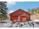 Two-car log garage with red doors that provides ample space for vehicles and storage at 29477 Blue Moon Dr, Evergreen, CO 80439