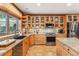 Well-lit kitchen with stainless steel appliances, custom cabinets, and tile floors at 29477 Blue Moon Dr, Evergreen, CO 80439