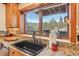 Kitchen sink with a view of the mountains and grill on the deck at 29477 Blue Moon Dr, Evergreen, CO 80439