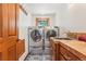 Functional laundry room with side-by-side washer and dryer, a utility sink, and cabinet storage at 29477 Blue Moon Dr, Evergreen, CO 80439