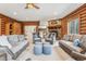 Spacious living room with log walls, a stone fireplace, and comfortable seating at 29477 Blue Moon Dr, Evergreen, CO 80439