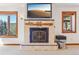 Living room featuring a decorative tile fireplace with natural accents and bright light from scenic windows at 29477 Blue Moon Dr, Evergreen, CO 80439