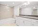 Bathroom features a tub and shower combination, and vanity with a gray countertop and white cabinets at 10295 E 59Th Ave, Denver, CO 80238