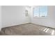 Bright bedroom features two large windows providing ample natural light and neutral carpeting at 10295 E 59Th Ave, Denver, CO 80238