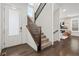 Welcoming entryway with hardwood floors, staircase with dark wood railing, and view into the living room at 10295 E 59Th Ave, Denver, CO 80238