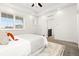 Bright bedroom featuring a plush bed, ceiling fan, and ample natural light from large windows and tray ceiling at 10295 E 59Th Ave, Denver, CO 80238