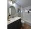 Modern bathroom with a sleek vanity, round mirror, and tiled shower/tub combination at 2521 Billings St, Aurora, CO 80011