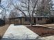 Charming brick home with a long driveway and covered carport, surrounded by mature trees at 2521 Billings St, Aurora, CO 80011