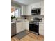 Bright kitchen with stainless steel appliances, white cabinets, and a stylish checkered floor mat at 2521 Billings St, Aurora, CO 80011