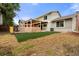 Exterior of the home including a patio and backyard with synthetic turf and a privacy fence at 12671 E Bates Cir, Aurora, CO 80014