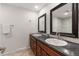 Bathroom featuring a dual sink vanity, framed mirrors, and a combined bath and shower at 12671 E Bates Cir, Aurora, CO 80014