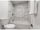 Bright bathroom featuring a tub-shower combo with modern tiling and fixtures at 12671 E Bates Cir, Aurora, CO 80014