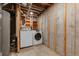 Unfinished basement laundry area with washer, dryer, and storage shelves at 12671 E Bates Cir, Aurora, CO 80014