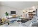 Open concept living room with kitchen view, stylish furniture, and hardwood floors at 715 S Alton Way # 5A, Denver, CO 80247