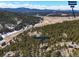 Stunning aerial view of property situated in valley with evergreen forests and snow capped mountains in the distance at 7395 Heiter Hill Dr, Evergreen, CO 80439