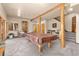 Carpeted basement with exposed wood beams, pool table, stairs and living space at 7395 Heiter Hill Dr, Evergreen, CO 80439