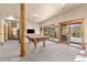 Spacious basement rec room with exposed wood beams, pool table and walk-out to deck at 7395 Heiter Hill Dr, Evergreen, CO 80439