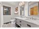 Bathroom with double marble vanity, gray cabinetry, mirrors, and natural light at 7395 Heiter Hill Dr, Evergreen, CO 80439