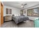 Bright bedroom with ceiling fan, two windows with wooded views, and neutral decor at 7395 Heiter Hill Dr, Evergreen, CO 80439