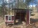 Rustic chicken coop with secure run and charming hen house detail, nestled amongst the trees at 7395 Heiter Hill Dr, Evergreen, CO 80439